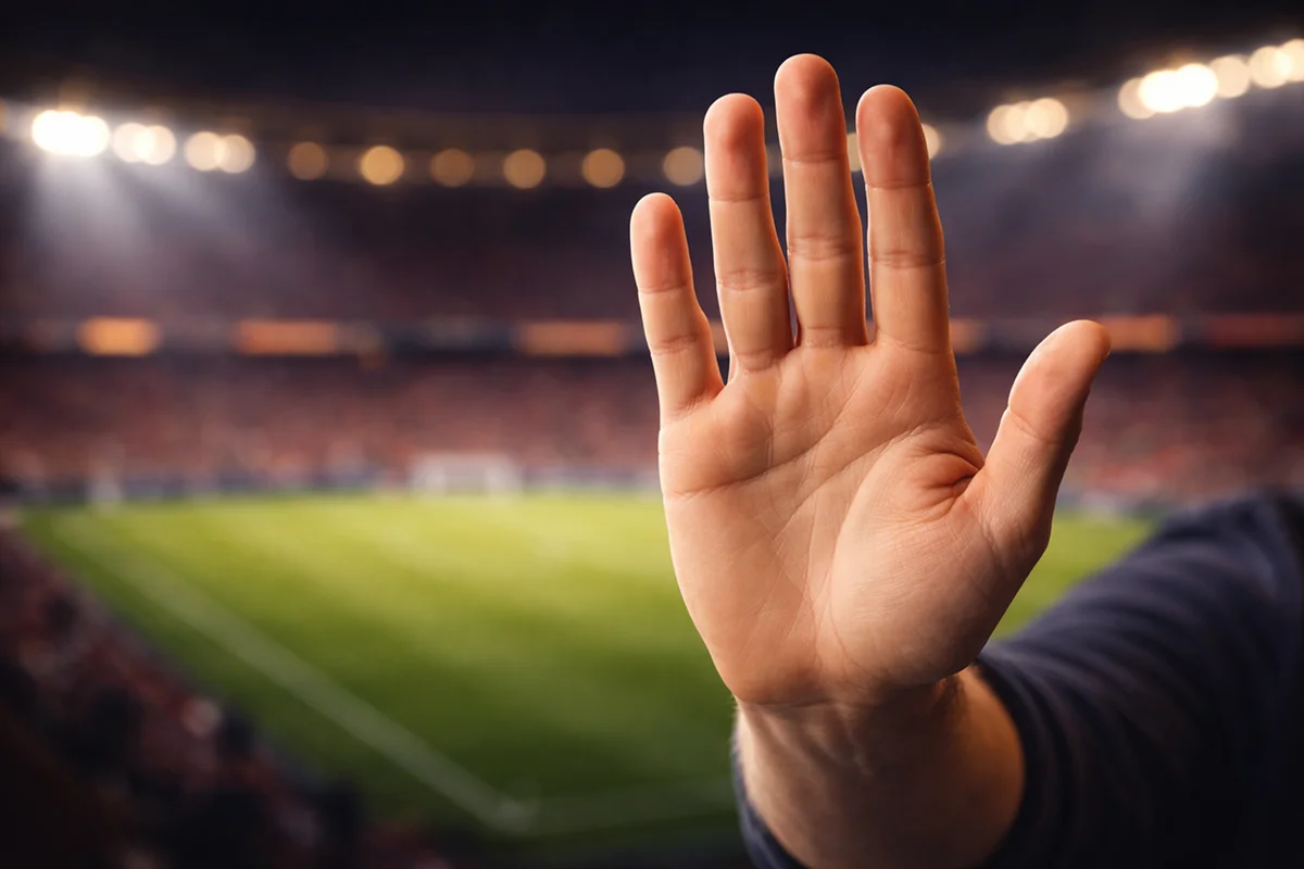 Stoppgeste vor verschwommenem Stadionhintergrund als Warnung vor Wettfehlern